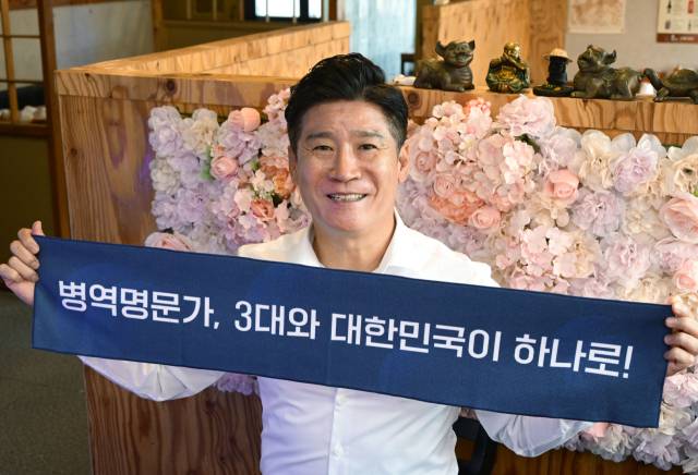 이상봉 씨가 인터뷰를 마친 후 병무청이 제공한 병역명문가 손펼침막을 들고 환하게 웃고 있다. 성형주 기자