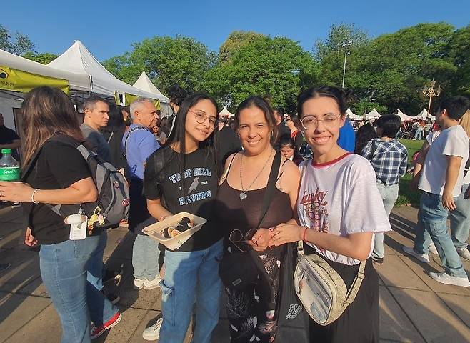 '한인 문화의 날' 행사에 참여한 세 모녀 (부에노스아이레스=연합뉴스) 김선정 통신원 = 아르헨티나의 수도 부에노스아이레스의 팔레르모 공원에서 2025년 한인 문화 행사 '하루 페스트가'가 2일(현지시간) 개최됐다. 한국 드라마 팬인 안드레아(52), 발렌티나(20), 레나타(15) 세 모녀가 김밥을 사서 먹고 있다. 2025.11.3 sunniek8@yna.co.kr