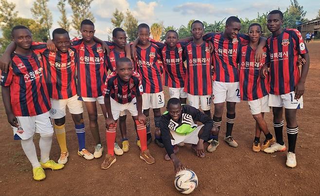 르완다 청소년들이 수원FC가 전달한 유니폼을 입고 기념사진을 찍고 있다.