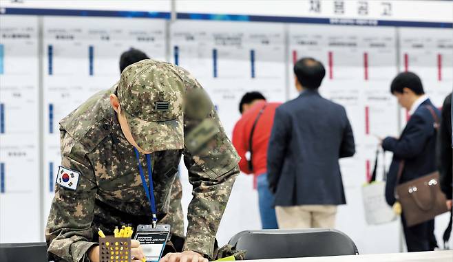 15~29세 청년 실업률이 작년 4분기부터 올해 3분기까지 네 분기 연속 악화됐다. 주력 산업인 제조업 부진 여파에 더해 정부·공공기관도 신입 사원 채용을 줄이고 있다. 지난 21일 서울 코엑스 마곡에서 열린 한 채용 박람회에서 군복을 입은 청년이 이력서를 작성하고 있다./뉴스1