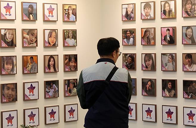 서울 종로구 적선현대빌딩에 열린 10·29 이태원 참사 기억·소통공간 이전 '별들의 집' 개소식에서 한 관계자가 희생자들의 사진을 바라보고 있다. 2024.11.10 (ⓒ뉴스1, 무단 전재-재배포 금지)