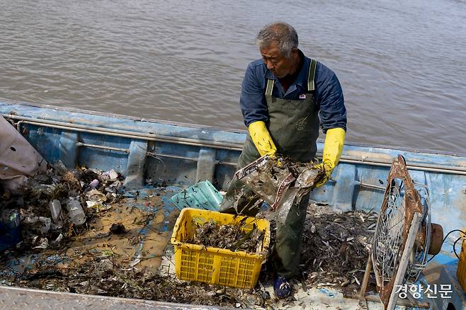 조 선장이 선풍기와 같은 기계를 이용해 어획물에서 비닐 등 해양쓰레기를 분리하고 있다. 강화 l 문재원 기자