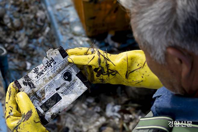 어획물에서 비닐 등 해양 쓰레기를 분리하던 조선장이 1970년대 출시한 라면 봉지를 확인하고 있다. 기자는 50여 년 전 라면 봉지가 아직도 강화 해상에 있는 것도 충격이었지만 너무 온전하게 발견된 것도 충격이었다. 강화 l 문재원 기자