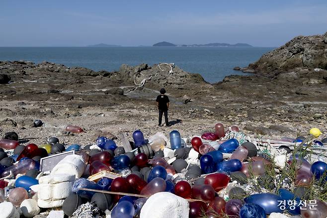 최황 녹색연합 자연 생태팀 활동가가 10월 1일 해양 쓰레기가 가득 쌓인 전남 신안군 임자면의 한 해안에서 바다를 바라보고 있다. 형형색색의 폐어구들과 쓰레기가 가득 쌓인 모습이 유네스코 세계 자연유산 구역이라는 게 믿기지 않았다. 마치 만들어 놓은 세트장 같았다.  신안 l 문재원 기자