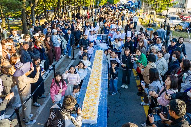 지난달 30일부터 2일까지 4일간 강릉 안목 커피거리 일원에서 열린 ‘2025 제17회 강릉커피축제’에서 1000여명의 관람객이 참여해 길이 5m의 대형 케이크를 완성하고 있다. 강릉시 제공
