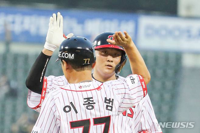 [서울=뉴시스] 권창회 기자 = 21일 오후 서울 송파구 잠실야구장에서 열린 2023 KBO리그 SSG랜더스 대 LG 트윈스 경기, 4회 말 2사 주자 2루서 LG 이재원이 1타점 적시타를 친 뒤 이종범 코치와 하이파이브를 하고 있다. 2023.07.21. kch0523@newsis.com