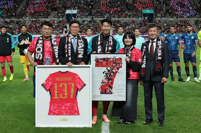 축구대표팀 주장 손흥민이 지난달 파라과이전에 앞서 A매치 역대 최다 출전 기록(137경기) 기념 유니폼을 전달받은 뒤 차범근 전 감독, 정몽규 대한축구협회장 등 관계자들과 기념사진을 찍고 있다.  연합뉴스