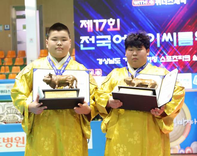 경상남도 거창군 거창스포츠파크실내체육관에서 열린 ‘제17회 전국어린이씨름왕대회’ 전국어린이씨름왕(등록/비등록)에서 우승을 차지한 허길녕, 이정훈이 메달을 메고 황소트로피와 상장을 들고 기념사진을 찍고 있다. /사진=대한씨름협회 제공