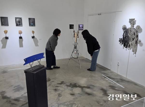 이탈 작가의 ‘이데올로기 기계’ 작품을 두 사람이 신기한 듯 바라보고 있다. 2025.11.4 /정진오기자 schild@kyeongin.com