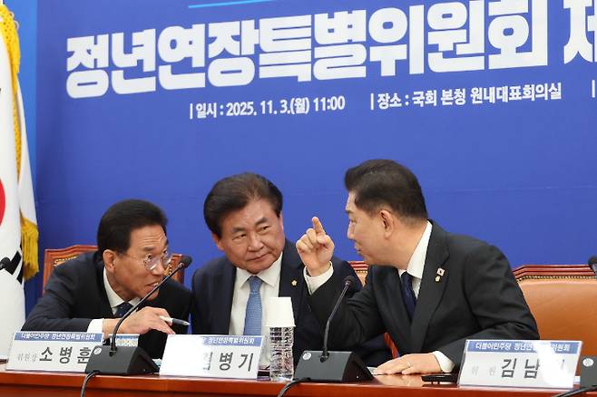 더불어민주당 김병기 원내대표가 3일 서울 여의도 국회에서 열린 정년연장특별위원회 제1차 본위원회의에서 소병훈 위원장(가운데), 김주영 간사(왼쪽)와 대화하고 있다. 연합뉴스