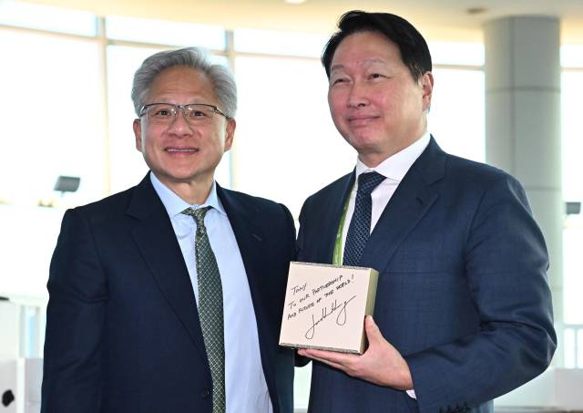 최태원(오른쪽) SK그룹 회장 겸 대한상공회의소 회장이 31일 경북 경주시 경주예술의전당에서 열린 아시아태평양경제협력체(APEC) CEO 서밋에서 젠슨 황 엔비디아 최고경영자(CEO가 선물한 AI슈퍼컴퓨터 ‘DGX스파크’를 들고 기념촬영을 하고 있다. 조태형 기자 2025.10.31