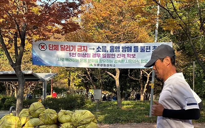 6일 오후 2시쯤 찾은 대구 두류공원 일원에 게시된 단체 달리기 금지 앞으로 한 주민이 달리기를 하고 있다. 구경모기자