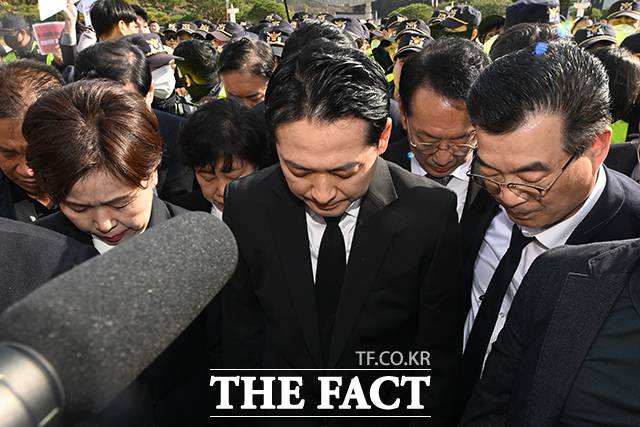 장동혁 국민의힘 대표(가운데)와 양향자 최고위원이 6일 오후 광주 북구 운정동 국립5·18민주묘지에서 광주시민들의 반발에 참배가 가로막히자 제단 옆에서 묵념하며 참배를 대신하고 있다. /광주=뉴시스