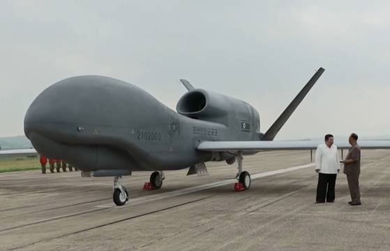 김정은 북한 국무위원장이 이병철 당 중앙군사위원회 부위원장과 미국의 고고도무인정찰기인 글로벌호크와 흡사한 ‘샛별-4’ 앞에서 대화를 나누고 있다. [조선중앙TV=연합뉴스]