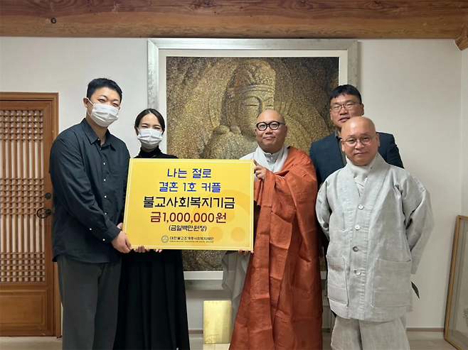 ‘나는 절로’ 1호 결혼 커플이 지난 1일 백양사에서 불교사회복지기금을 전달하고 있다. <조계종사회복지재단>