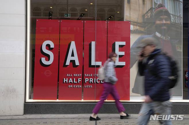 [런던=AP/뉴시스] 영국 런던 시내에서 세일을 알리는 상점 앞을 시민들이 지나가고 있다. 자료사진. 2025.11.06