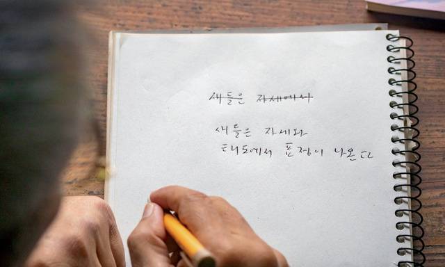 서재에 딸린 정원에선 물까치가 연신 울어댔다. 그 풍경을 바라보던 시인이 노트에 무언가를 써 내려갔다.