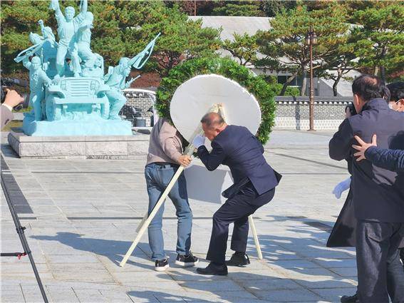 장동혁 국민의힘 당 대표가 6일 오후 3시50분쯤 광주를 찾아 국립 5·18민주묘지를 참배하기 위해 추모의 문 앞에 도착하기 직전 광주전남촛불행동 회원들이 당 대표 조화를 치우고 있다. 이 과정에서 국민의힘 관계자와 촛불행동 회원 간 '뺏고 빼앗기는' 격렬한 몸싸움이 벌어졌다. ⓒ 시사저널 정성환