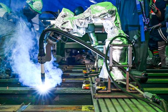 지난달 20일 울산 HD현대미포 3도크 갑판 블록 용접 시연회에서 로봇이 장애물을 피해 자동 용접을 하고 있다. [사진 HD현대]
