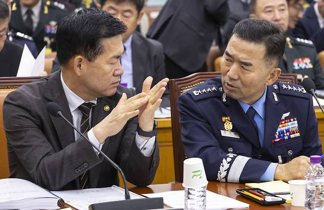 Defense Acquisition Program Administration Commissioner Seok Jong-gun (left) and Joint Chiefs of Staff Chair Gen. Jin Yong-sung talk during a parliamentary audit of the 2025 national defense budget at the National Assembly on Oct. 30. (Yonhap)