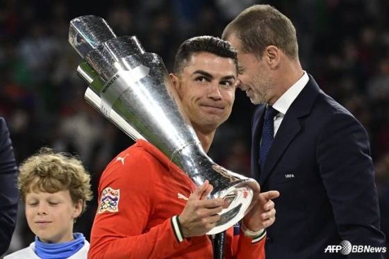 크리스티아누 호날두(가운데)가 유럽축구연맹(UEFA) 네이션스리그(NL) A 챔피언십 결승전에서 스페인을 꺾고 트로피를 들며 미소짓고 있다. /AFPBBNews=뉴스1