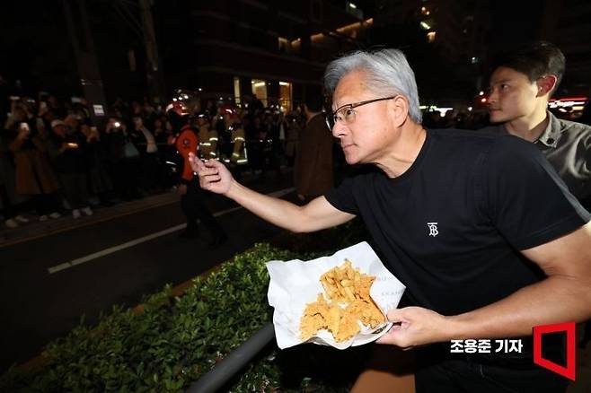 젠슨황 엔비디아 최고경영자가 지난달 30일 이재용 삼성전자 회장, 정의선 현대자동차그룹 회장과 서울 강남구 깐부치킨에서 회동 중 시민들에게 치킨을 내밀고 있다. 조용준 기자