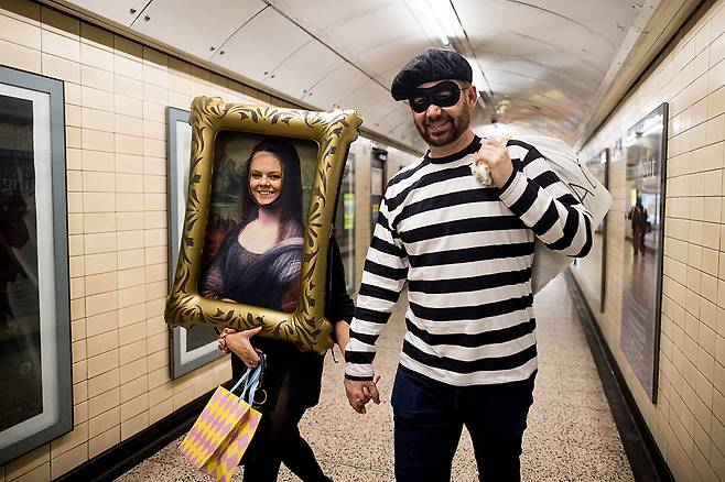 지난달 31일(현지시간) 루브르 박물관 도난 사건을 소재로 한 핼로윈 의상을 입은 한 커플이 런던 지하철을 지나가고 있다.
