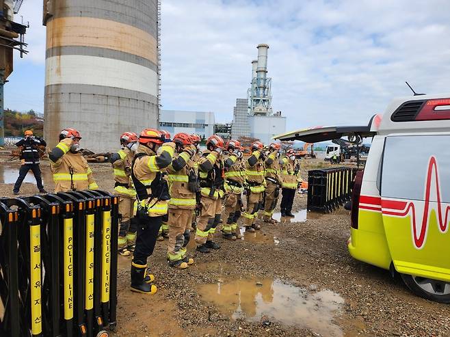 9일 오전 소방당국이 울산화력발전소 보일러타워 붕괴사고 현장에서 김모(44)씨의 시신을 수습한 뒤, 구조대원들이 김씨를 태운 구급차를 향해 거수경례를 하고 있다. 울산소방본부 제공