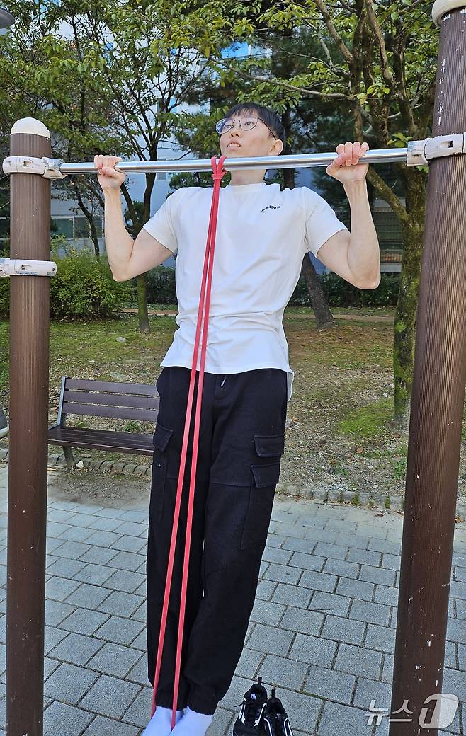 밴드를 활용한 턱걸이 시범을 보이는 김동호 씨. ⓒ News1 권혁준 기자