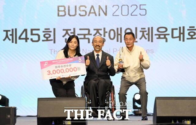 임규모 세종시장애인체육회 사무처장(오른쪽)과 이연경 총괄부장(왼쪽)이 정진완 대한장애인체육회장에게 사격부문 김정남 선수의 최우수선수상을 대리수상하고 있다. /세종시