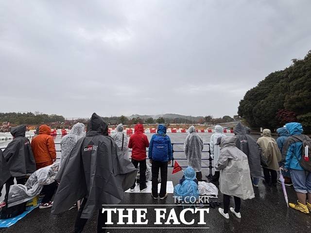 비가 내리는 가운데 관람객들이 우비와 장화를 착용한 채 오카자키 슈퍼 스페셜 스테이지(SSS) 경기를 지켜보고 있다. /황지향 기자