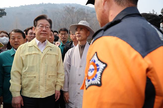 이재명 대통령(당시 더불어민주당 대표)이 지난 3월 27일 오전 산불로 전소된 경북 의성군 고운사를 찾아 소방대원의 현장 브리핑을 듣고 있다./뉴스1