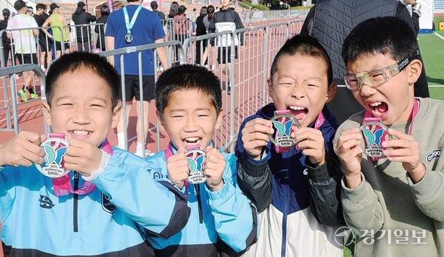 마라톤 꿈나무들이 5㎞ 완주 메달을 들어 보이며 기쁨을 만끽하고 있다. 조주현·윤원규기자