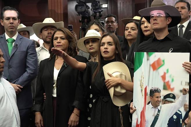 5일(현지시간) 멕시코 미초아칸주 의회에서 총격으로 사망한 카를로스 만소 시장을 미망인 그레시아 키로스(가운데) 등이 기리고 있다. [EPA 연합뉴스]