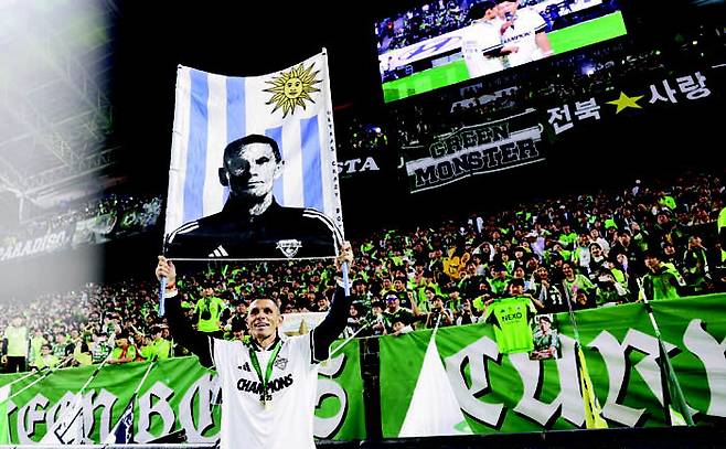 거스 포옛 전북 현대 감독이 지난 8일 전주월드컵경기장에서 진행된 K리그1 우승 세리머니에서 자신의 얼굴이 그려진 응원도구를 들고 기념사진을 찍고 있다. 프로축구연맹 제공