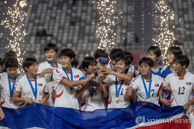 우승 트로피를 들고 기뻐하는 북한 U-17 여자 축구대표팀 선수들 [EPA=연합뉴스]