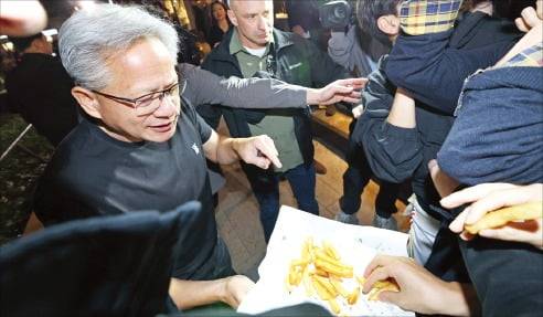 젠슨 황 CEO가 시민들에게 치즈스틱을 나눠주고 있다. /문경덕 기자