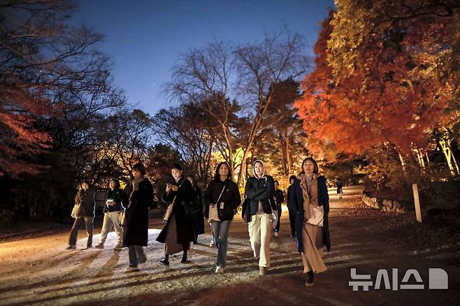 [서울=뉴시스] 정병혁 기자 = 10일 서울 종로구 창경궁에서 열린 2025 야간관람 '동궐동락'을 찾은 궁 내부를 걷고 있다. 2025.11.10. jhope@newsis.com
