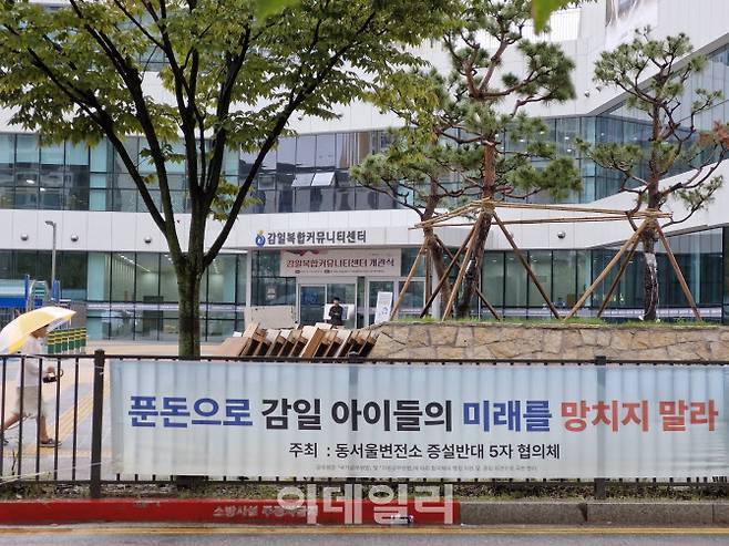 한 어린이가 지난달 10일 경기도 하남시 동서울변전소의 500kV 변환소 신설 및 특별지원금 지급에 반대하는 현수막 옆으로 걸어가고 있다. 500kV 변환소는 에너지 고속도로 관련 총길이 280km 동해안~수도권 HVDC 송전선로의 2단계 종착지다. 동서울변전소 증설반대 5자협의체에는 동서울변환소반대TF, 하남시청, 하남시의회, 더불어민주당 추미애 의원(하남갑), 국민의힘 이용 전 의원(하남갑)이 참여하고 있다. (사진=최훈길 기자)