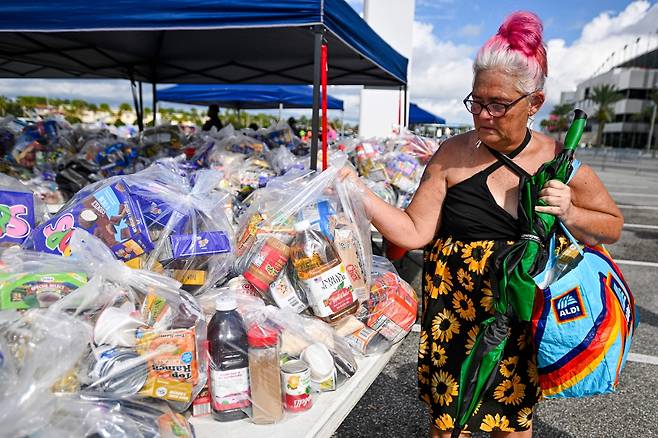 9일(현지시간) 미국 플로리다주 데이토나비치의 한 저소득층 식품 지원 프로그램(SNAP) 수혜자 대상 무료 식품 배포 행사에서 한 여성이 식료품 가방을 들고 있다. AFP연합뉴스