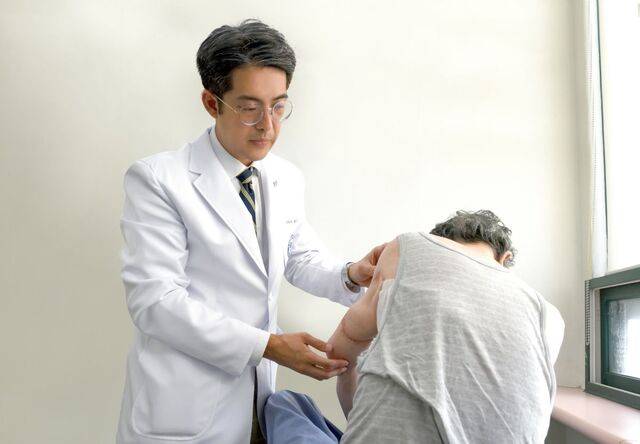 한양대병원 배근형 교수가 왼쪽 팔에 육종 제거 수술을 받은 80대 환자의 수술 부위를 살펴보고 있다.