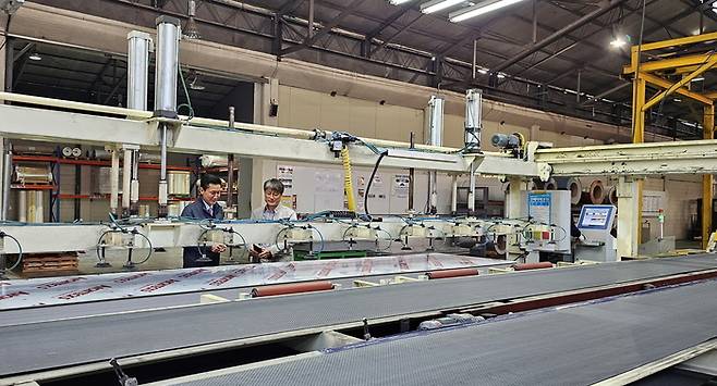 스마트공장으로 탈바꿈한 홍성산업 내 작업 공간을 김병식 홍성산업 대표(왼쪽)와 김재용 삼성전자 스마트공장지원센터 위원이 살펴보고 있다. 삼성전자