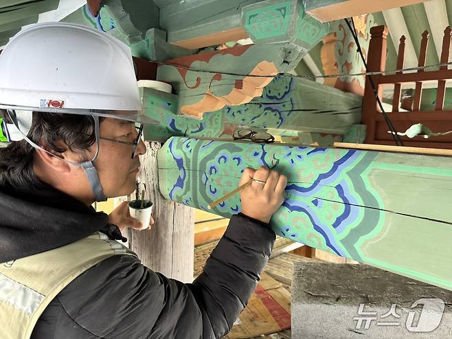 춘천 청평사 회전문 전통 단청에 동록 안료를 적용하는 모습.(춘천시 제공, 재판매 및 DB금지)