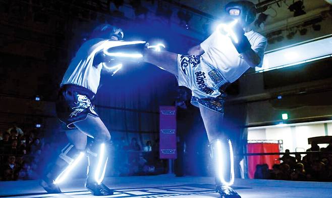 마쓰에다 후미노리(오른쪽)씨가 10일 일본 도쿄 고라쿠엔홀에서 열린 시각장애인 킥복싱 매치 ‘로 비전(low vision) 킥복싱’에서 나리사와 슌스케씨에게 발차기 공격을 하고 있다. 링에 오른 두 사람은 ‘망막색소변성증’이란 난치병을 가진 시각장애인으로 글러브와 정강이 보호대에 부착한 LED 불빛을 인식하며 경기를 치렀다./히가시스포웹