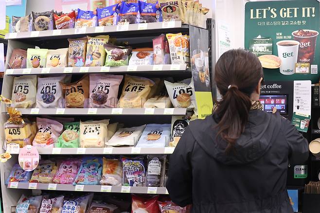 A customer looks at snacks displayed at a CU convenience store in Seoul on Oct. 14, 2024. [YONHAP]