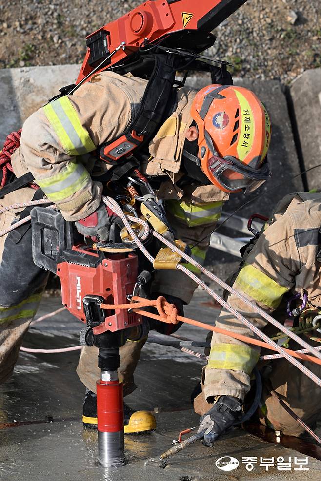 13일 오후 용인시 경기소방학교 붕괴사고훈련장에서 진행된 천공파괴 훈련에 참가한 소방관계자가 레펠에 매달린 상태로 벽에 천공을 내고 있다. 임채운기자