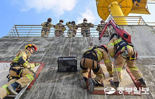 13일 오후 용인시 경기소방학교 붕괴사고훈련장에서 진행된 천공파괴 훈련에 참가한 소방관계자가 레펠에 매달린 상태로 벽에 천공을 내고 있다. 임채운기자