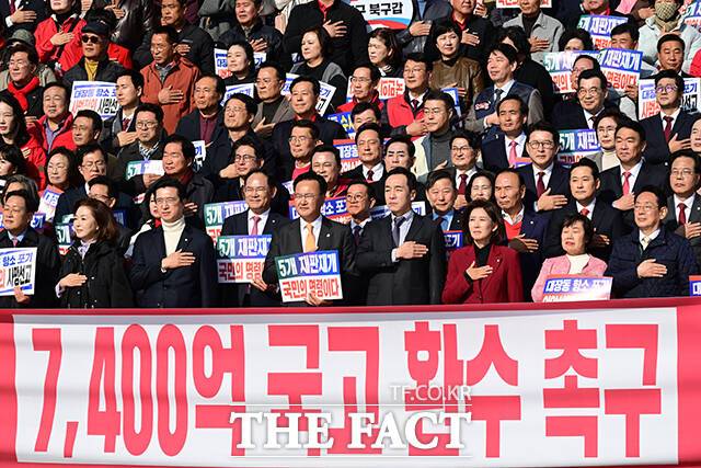 장동혁 국민의힘 대표를 비롯한 참석자들이 12일 오전 서울 여의도 국회에서 열린 '대장동 일당 7400억 국고 환수 촉구 및 검찰 항소포기 외압 규탄대회'에 참석해 국기에 경례하고 있다. /남윤호 기자