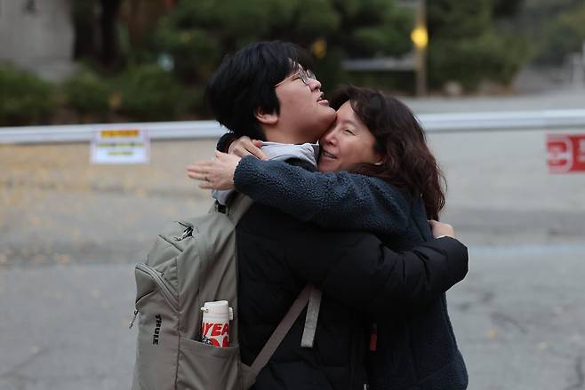 2026학년도 대학수학능력시험일인 13일 오전 서울 종로구 경복고등학교 앞에서 수험생이 어머니의 응원을 받으며 고사장으로 향하고 있다. /뉴스1