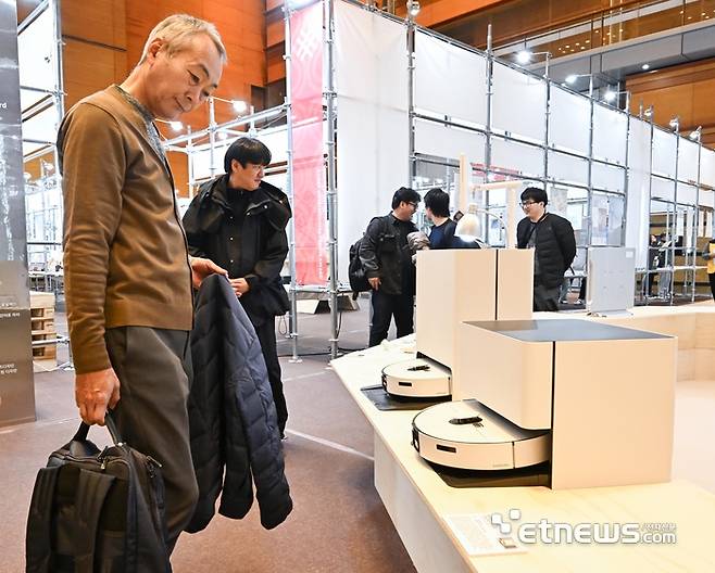 13일 서울 강남구 코엑스에서 열린 디자인코리아에서 참관객이 삼성전자의 AI물걸레 로봇청소기 '비스포크AI 스팀90 시리즈'를 살펴보고 있다.  이동근기자 foto@etnews.com